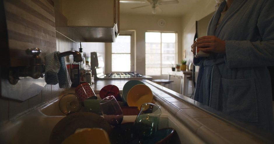 A moody contrasty scene showing the kitchen sink full of dirty dishes, and our character starting at them, with a strong sun streaming from the kitchen door. 
